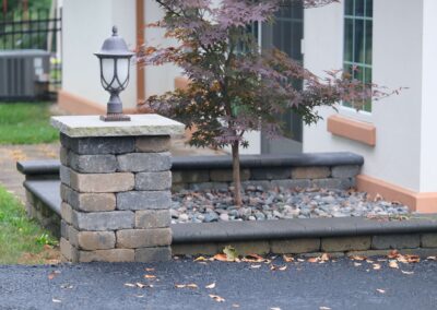 stone bed next to a driveway and in front of a yard