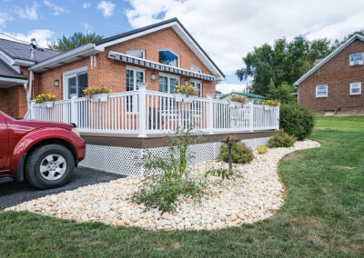Stone bed in front of a house and by a driveway