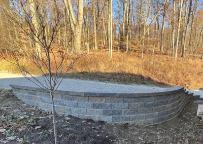 stone block retaining wall beside a gravel driveway